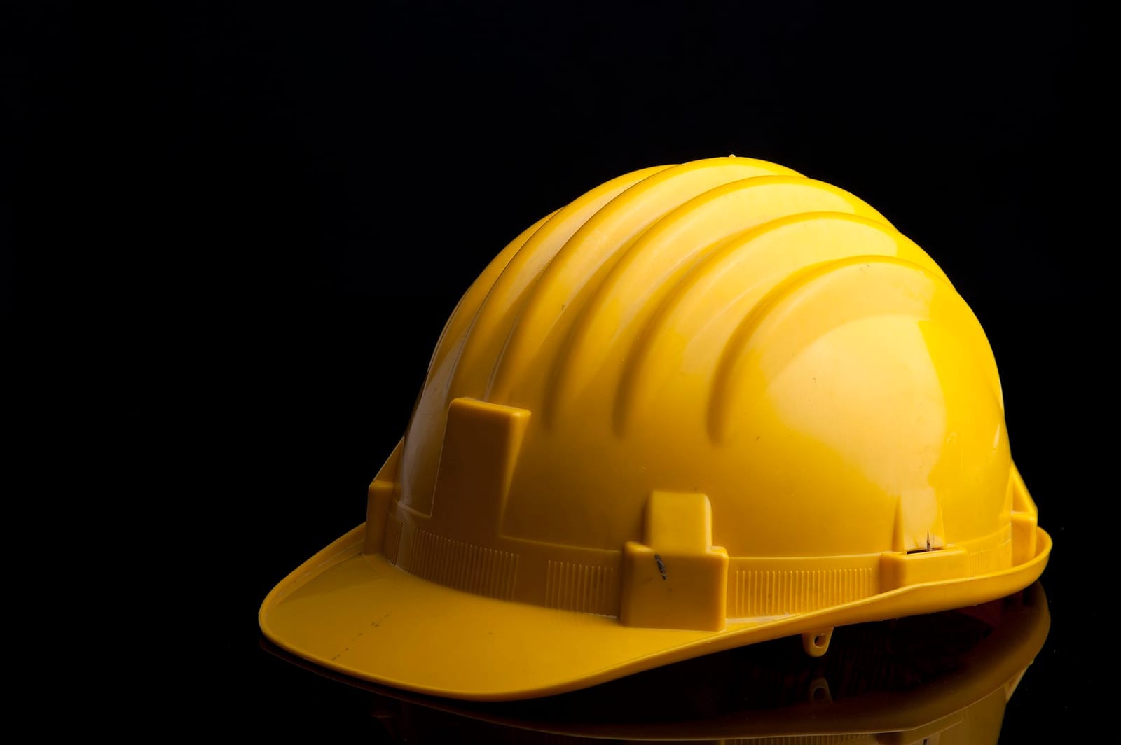 Capacete de segurança amarelo sobre fundo preto